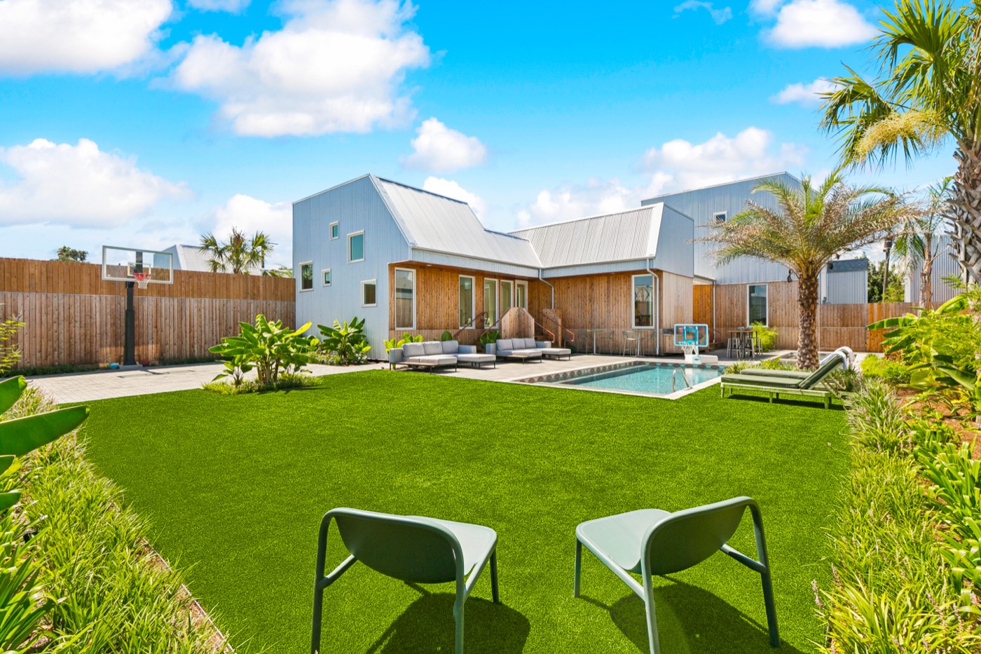 Big lawn with cornhole boards, villa and pool behind at a New Orleans group rental